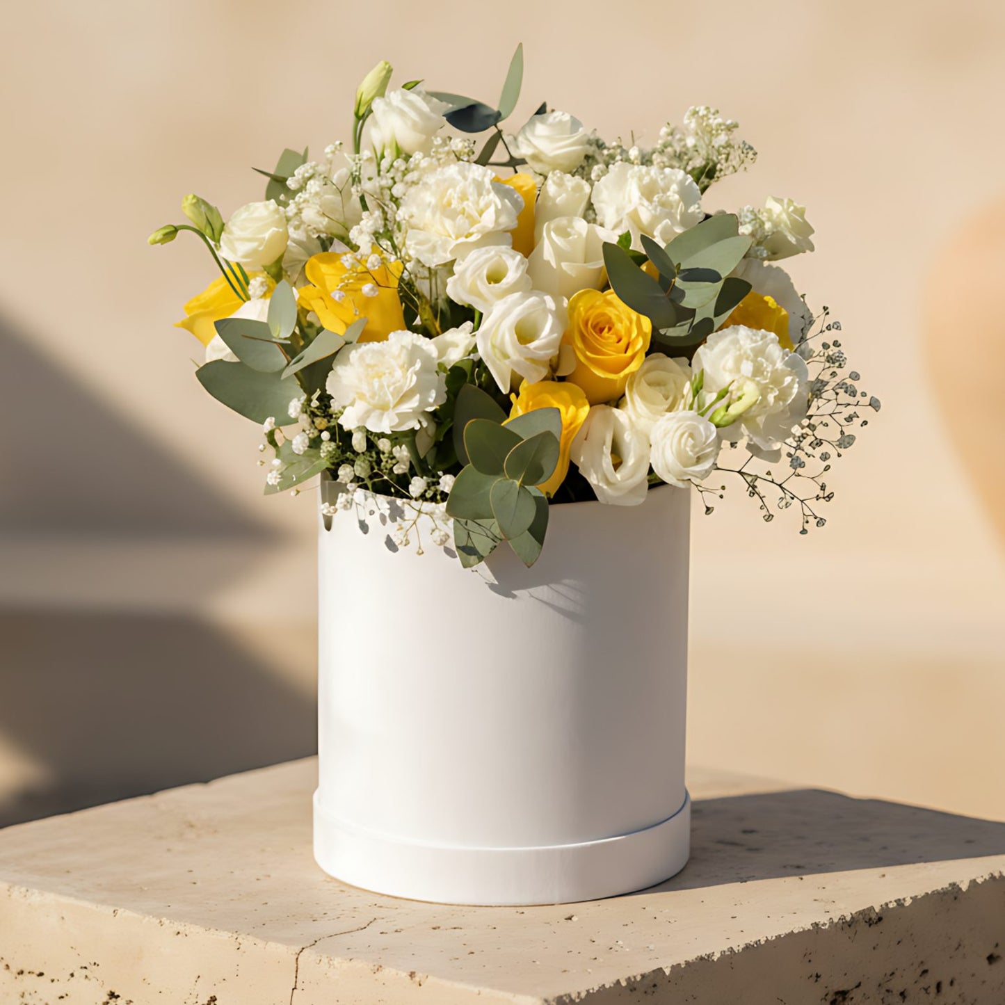 White velvet box arrangement with white and yellow roses, carnations, lisianthus, eucalyptus, and gypsophila
