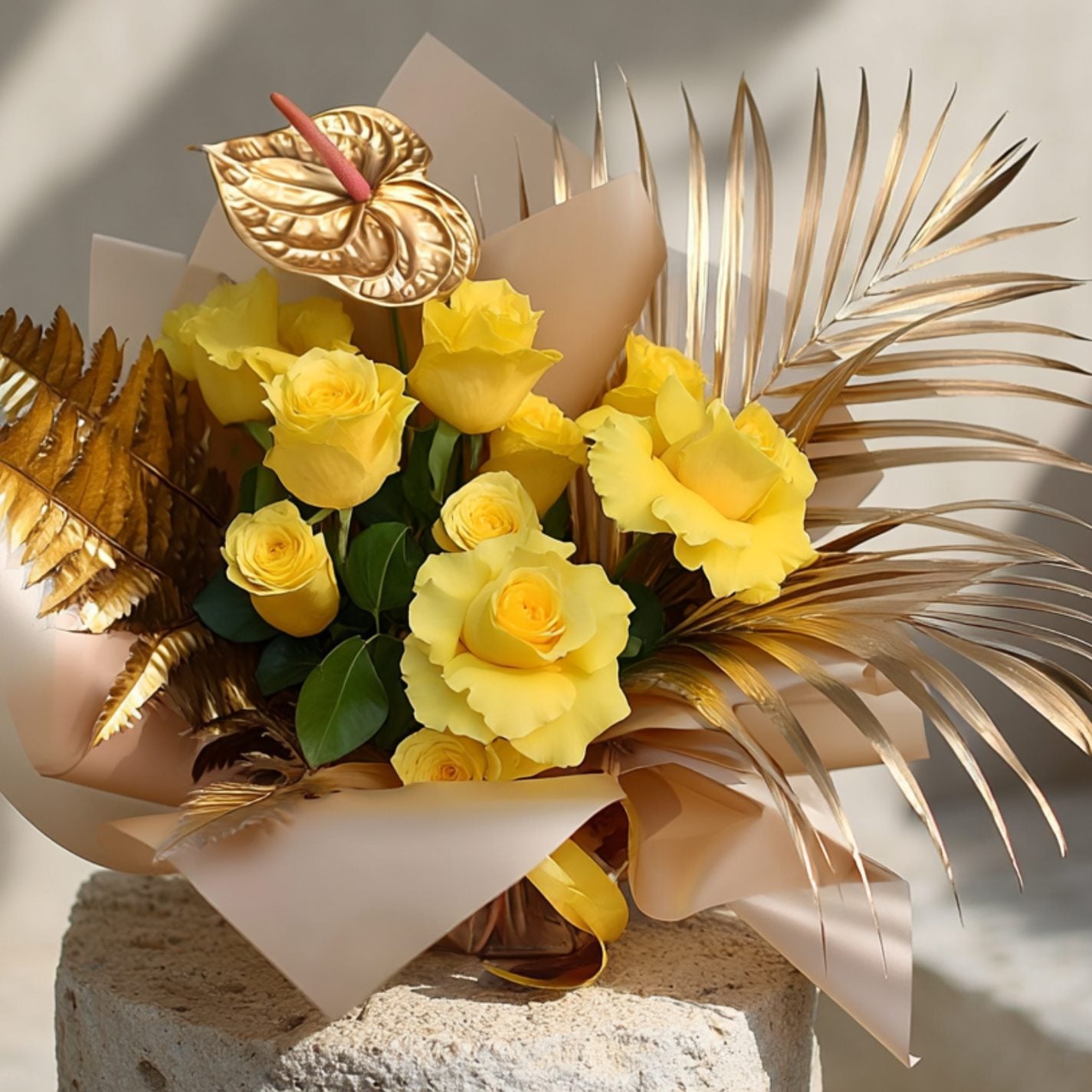Handcrafted bouquet of yellow roses with golden anthurium and gold accents in luxurious gold wrapping by Aiwa Flowers Dubai