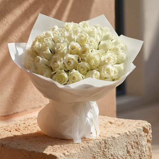 Hand-tied bouquet of 55 white roses in elegant white wrapping by Aiwa Flowers Dubai