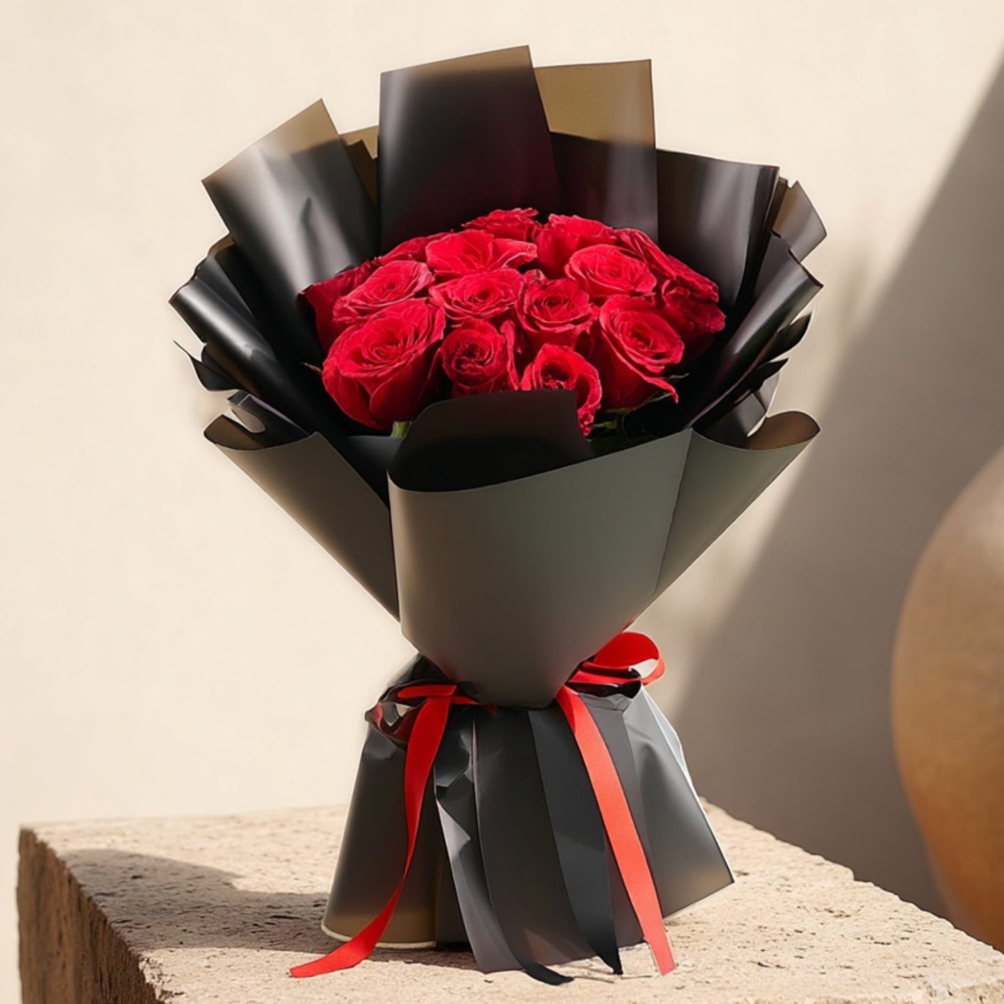 Hand-tied bouquet of 15 red roses in elegant black wrapping by Aiwa Flowers Dubai