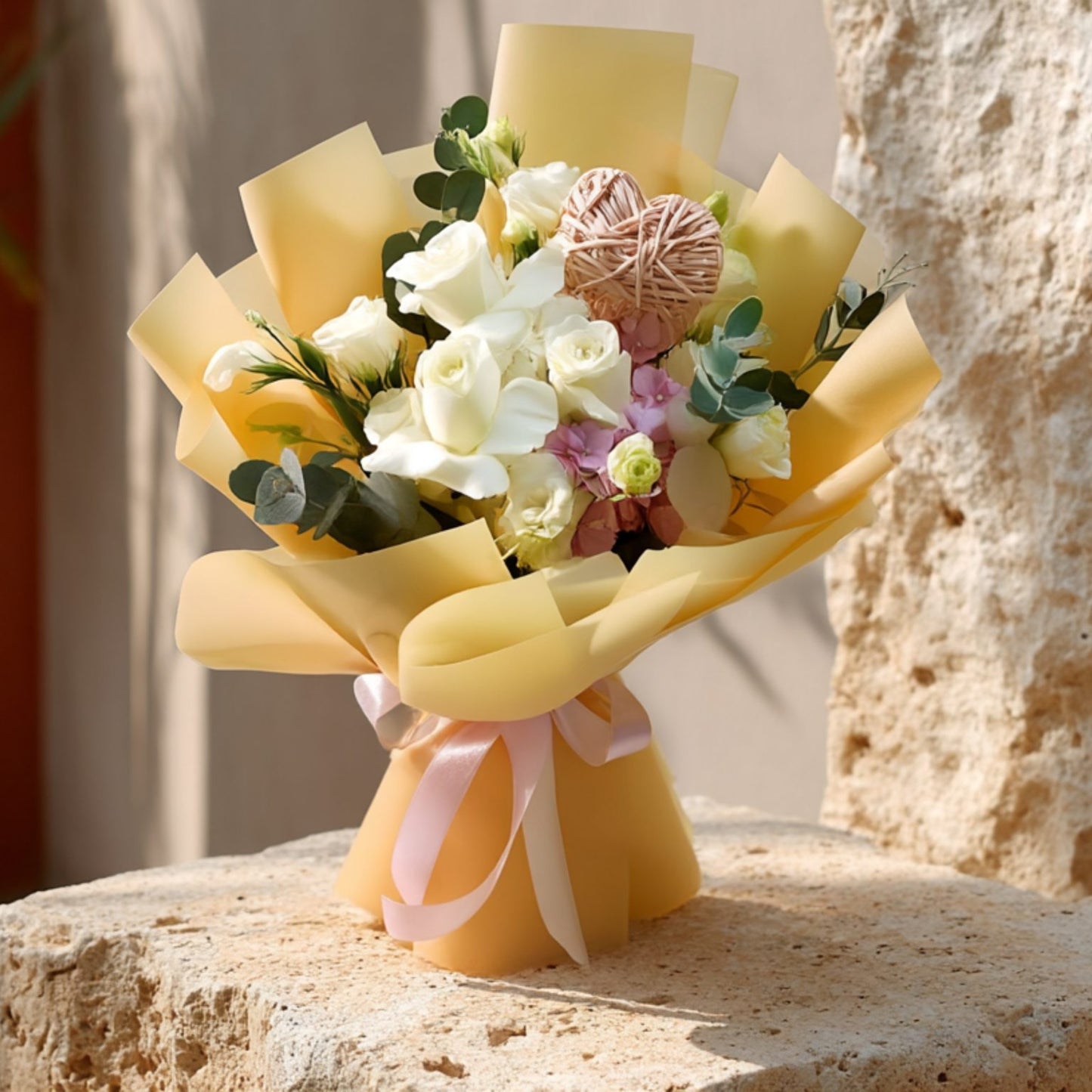 Hand-tied bouquet of white roses with lisianthus, pink hydrangea, eucalyptus, and a heart detail in gold wrapping by Aiwa Flowers Dubai