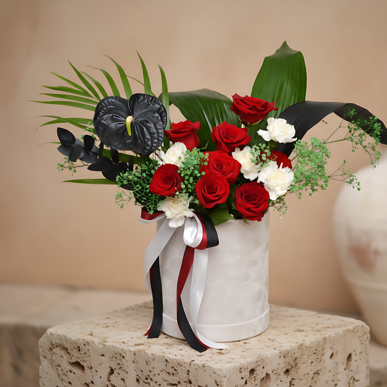 Fujairah white velvet box arrangement with red roses, white carnations, black anthurium, and green gypsophila by Aiwa Flowers Dubai
