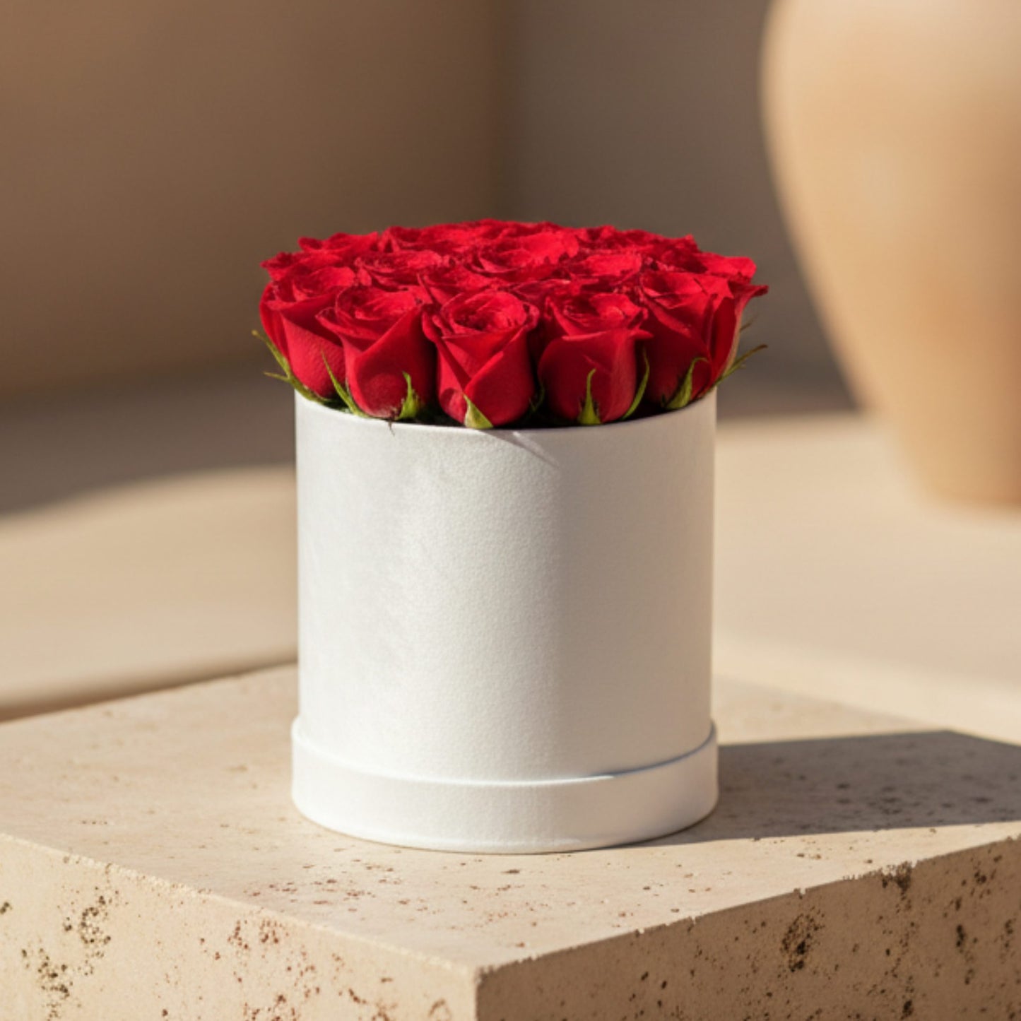 White velvet round box arrangement with 15–20 fresh red roses