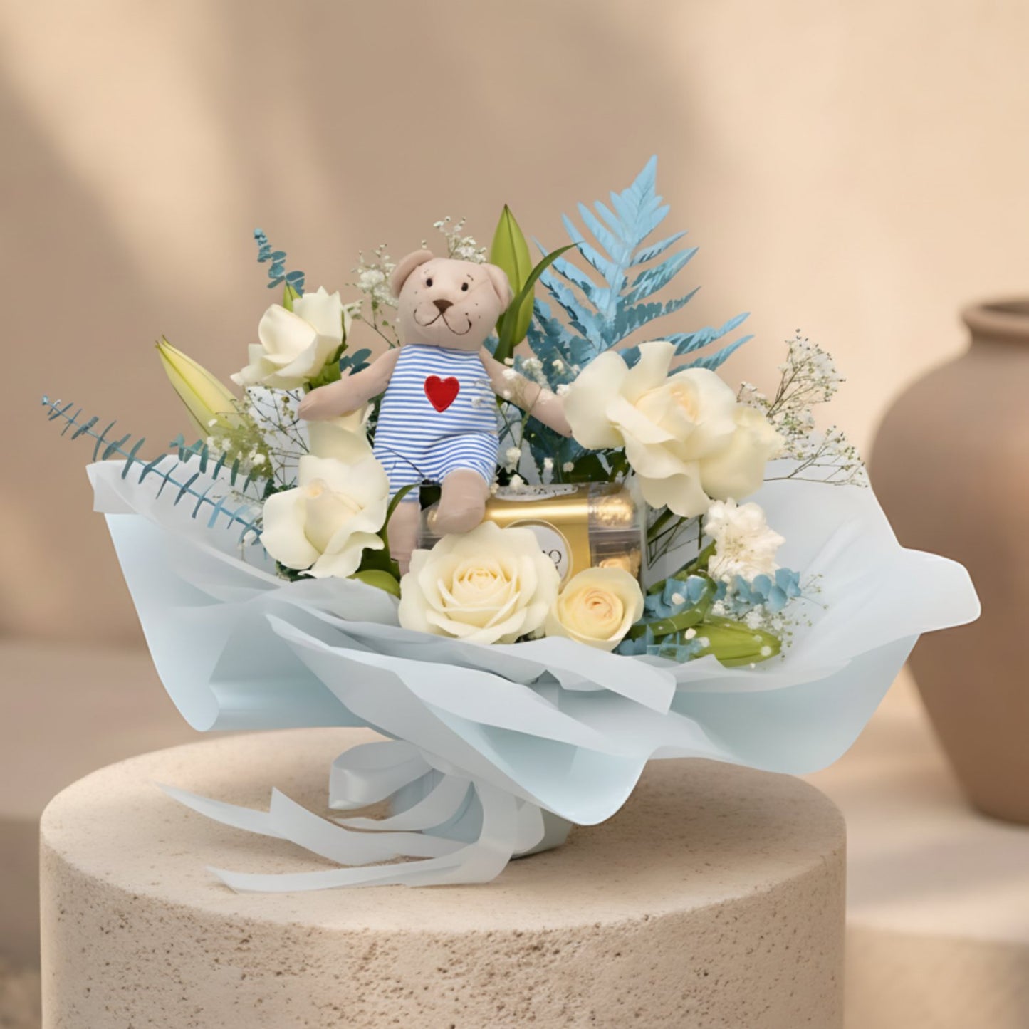 Baby boy bouquet with white roses, carnations, lilies, teddy bear and Ferrero Rocher chocolates in blue wrapping.