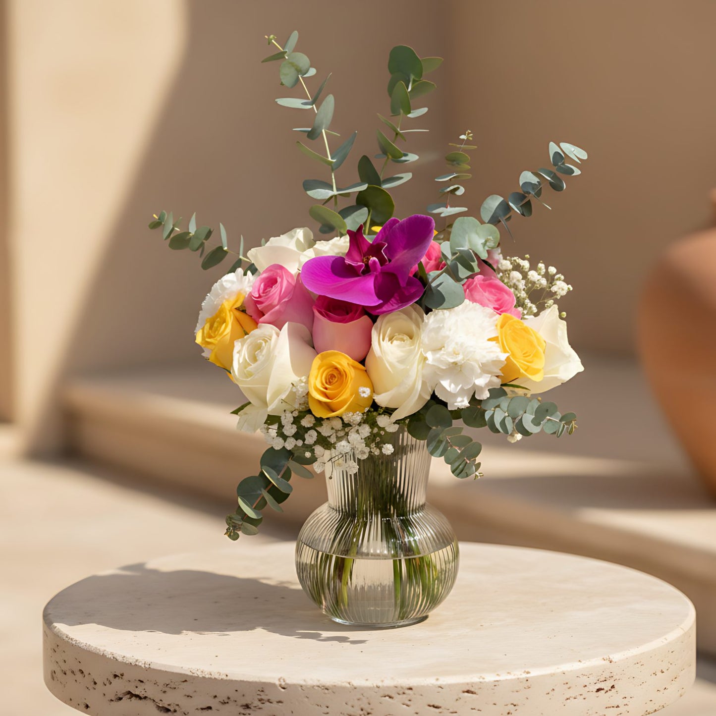 Layla floral arrangement with mixed roses, purple orchid, carnations and gypsophila in a clear vase by Aiwa Flowers