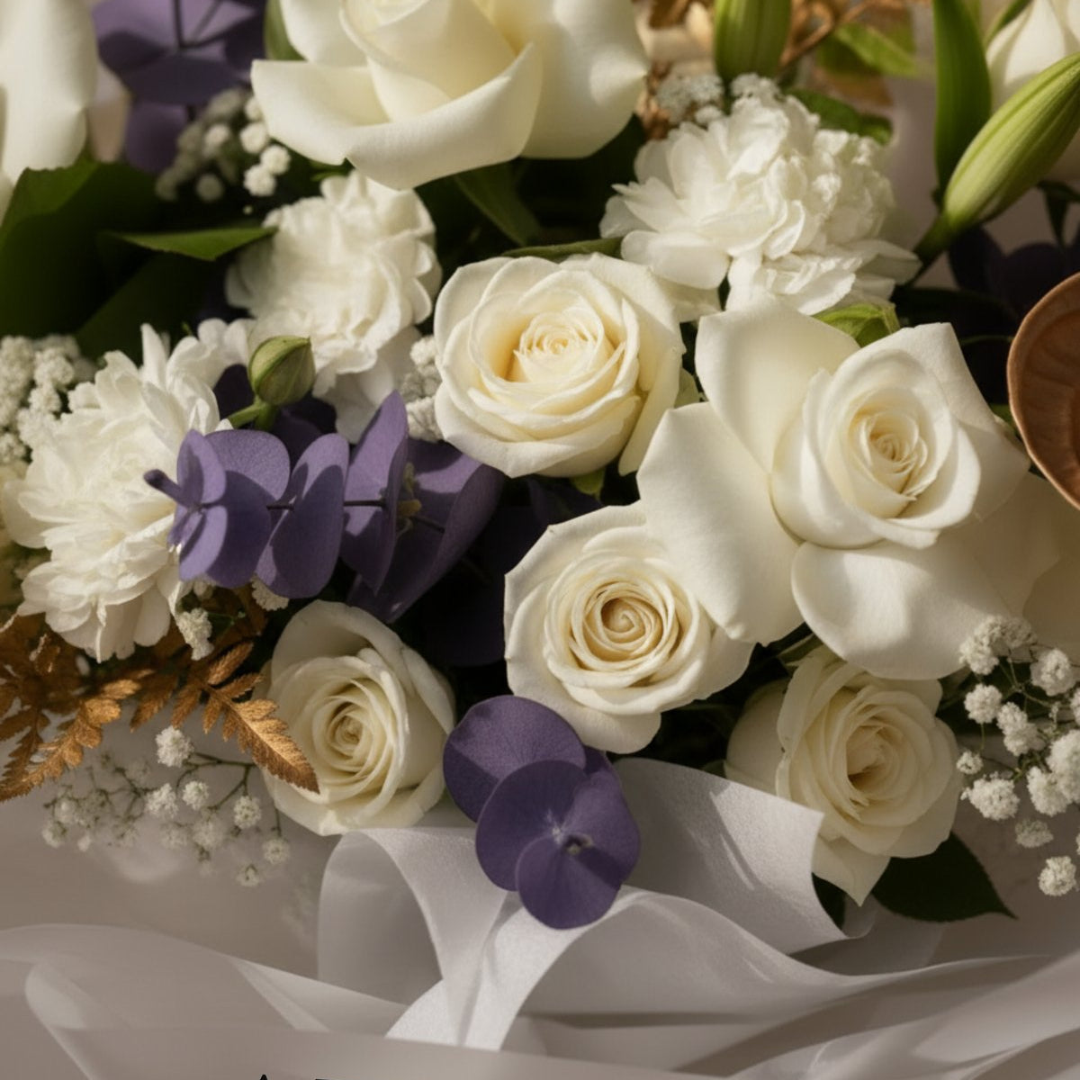 Close-up of white roses, baby's breath and purple accents with gilded leaves — White Velvet by AIWA Flowers