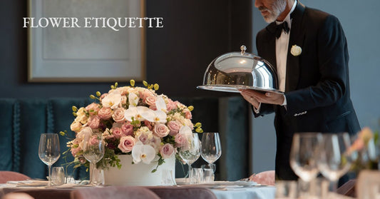 Waiter presenting a pink rose and orchid centerpiece at an elegant dinner table, illustrating flower etiquette for special occasions