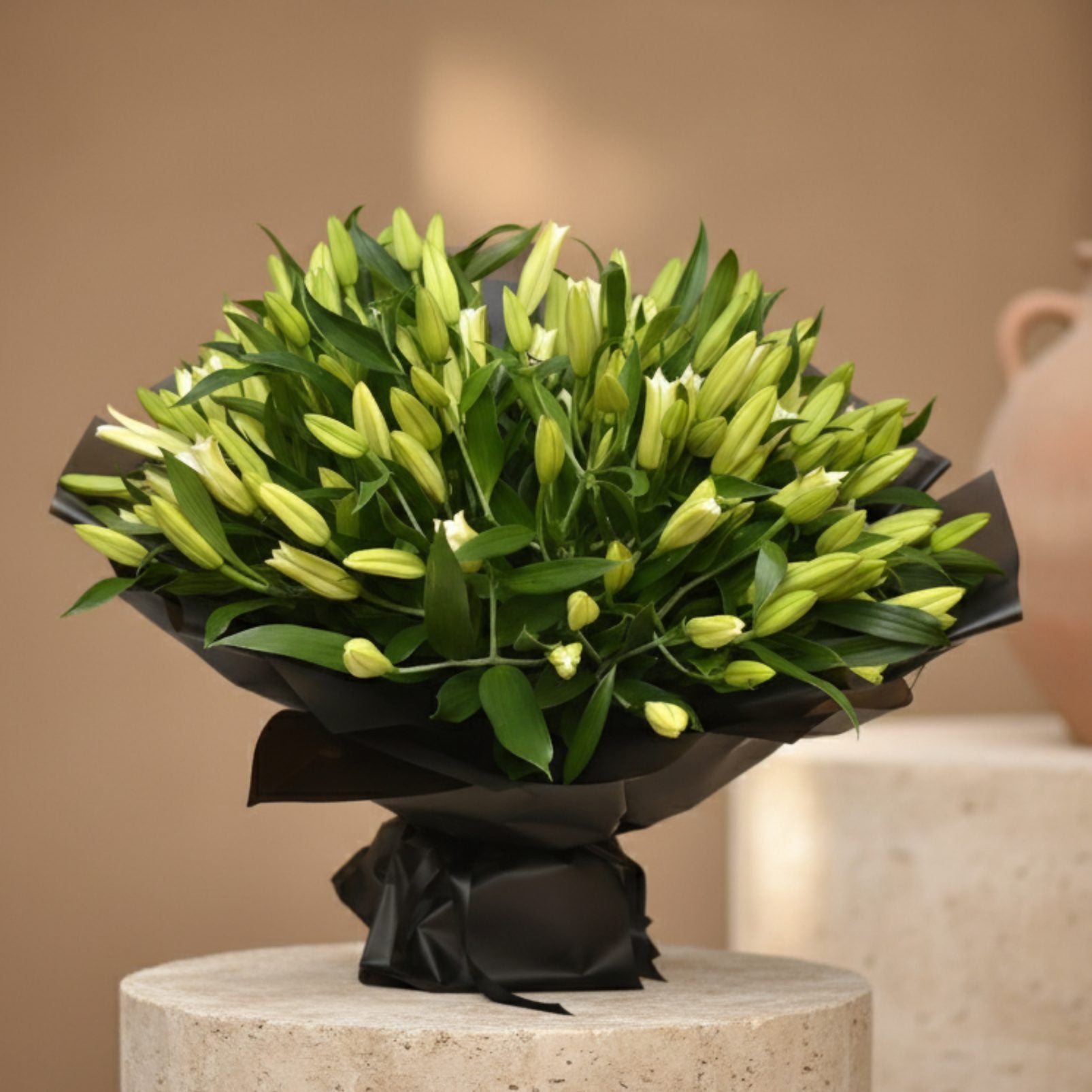 55 Lilianna hand-tied bouquet with 55 white lilies in black wrapping by Aiwa Flowers