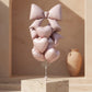 Blush Bow Bundle balloon bouquet with blush heart balloons and large bow foil balloon tied together.