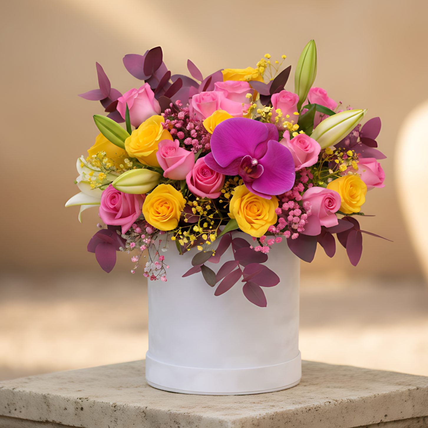 White velvet box arrangement with pink and yellow roses, purple orchid, lilies, and colorful gypsophila