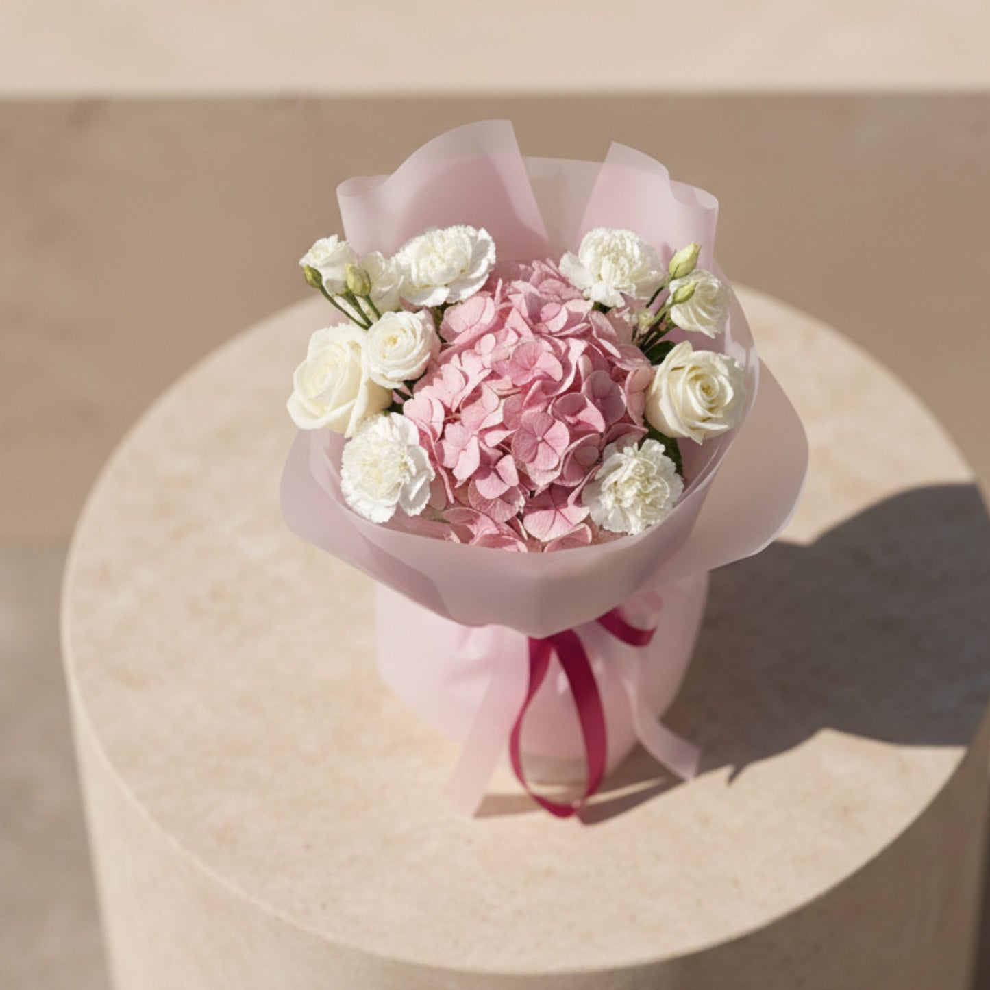 Top view of Deva bouquet with pink hydrangea centerpiece and white roses in pink wrapping.