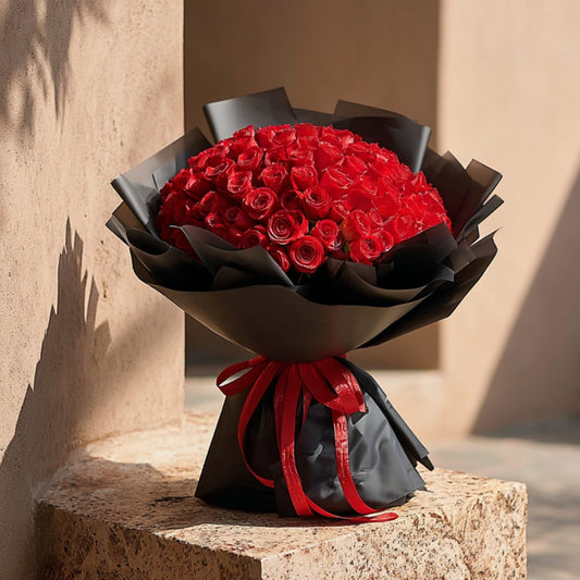Hand-tied bouquet of 101 red roses in elegant black wrapping by Aiwa Flowers Dubai