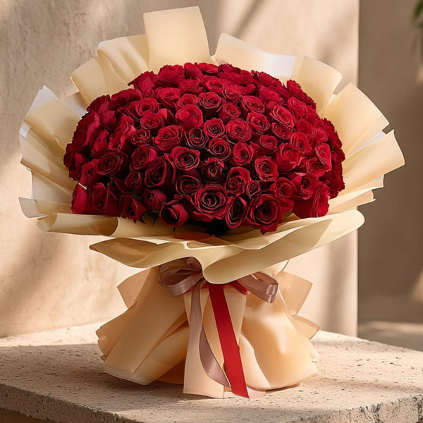 Hand-tied bouquet of 101 red roses in luxurious gold wrapping by Aiwa Flowers Dubai
