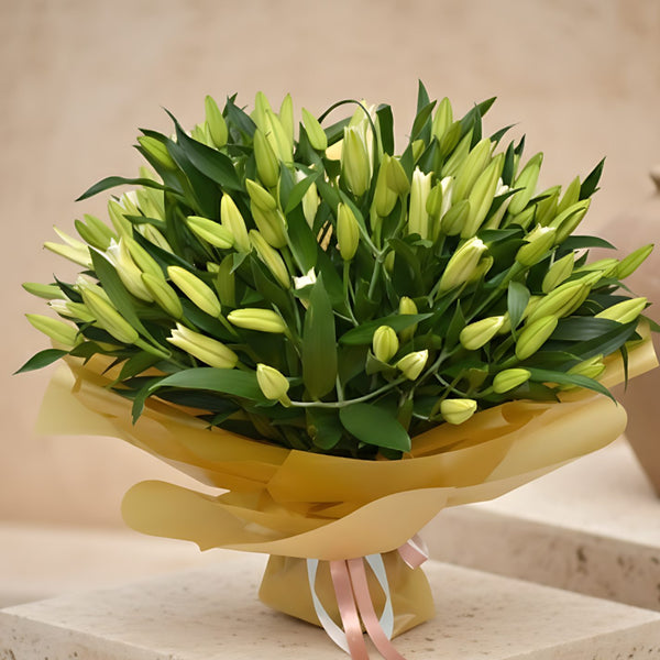 55 Lilies Gold hand-tied bouquet of white lilies wrapped in gold paper by Aiwa Flowers Dubai