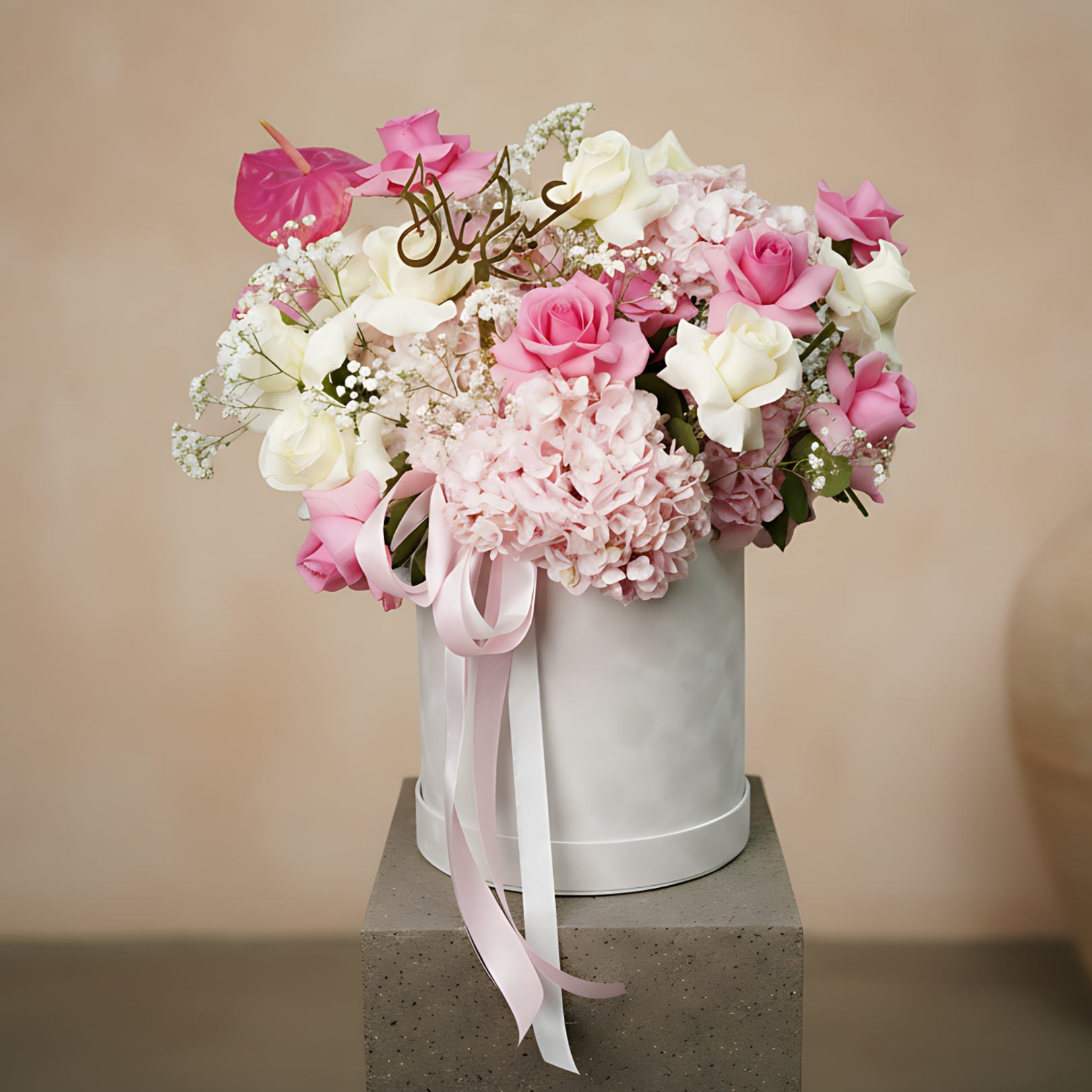 Al Adha Flowers arrangement with pink and white roses, hydrangeas, pink anthurium, gypsophila, and Arabic topper in white velvet box by Aiwa Flowers Dubai