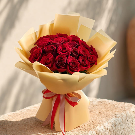 Hand-tied bouquet of 25 red roses in elegant gold wrapping by Aiwa Flowers Dubai