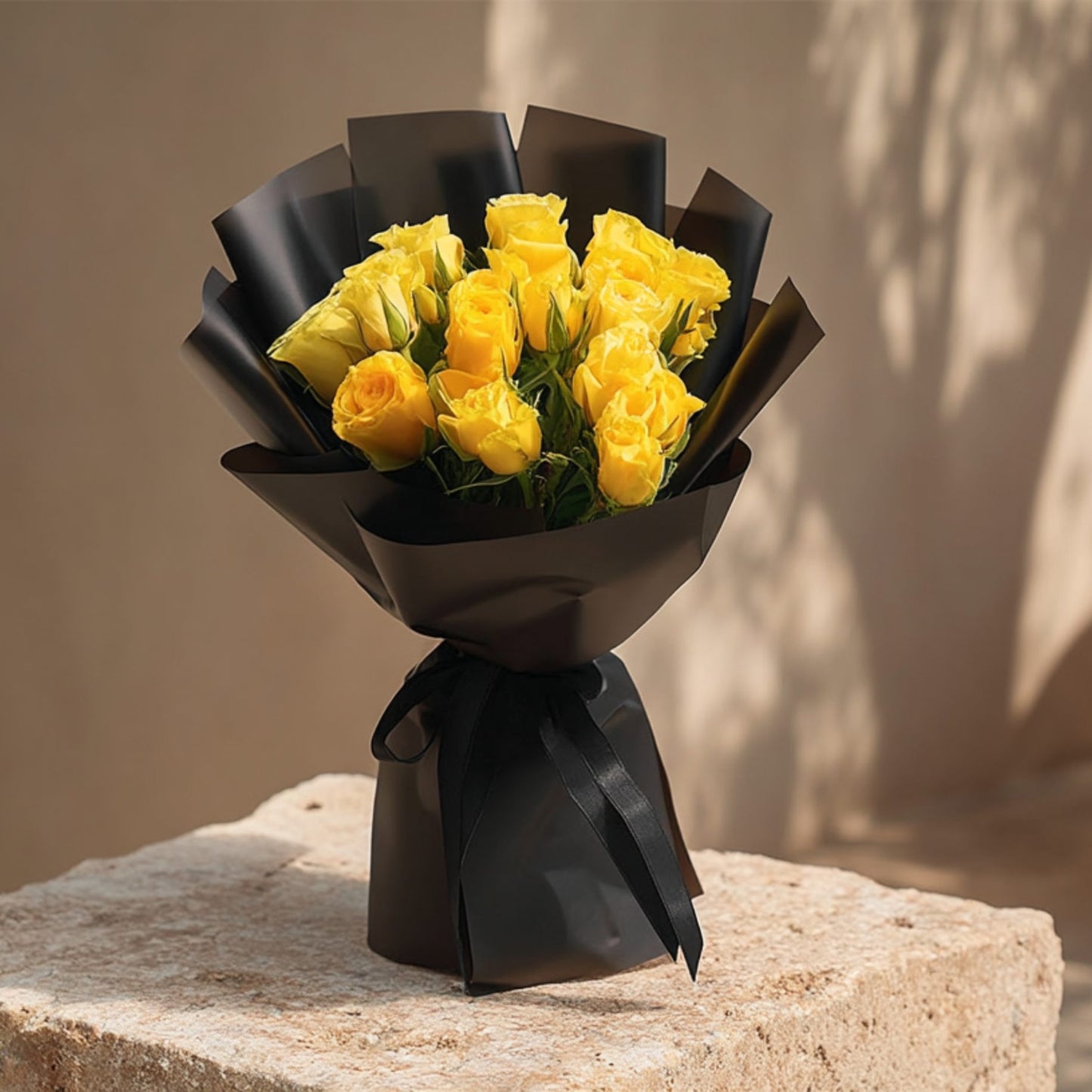 Hand-tied bouquet of 15 yellow roses in elegant black wrapping by Aiwa Flowers Dubai
