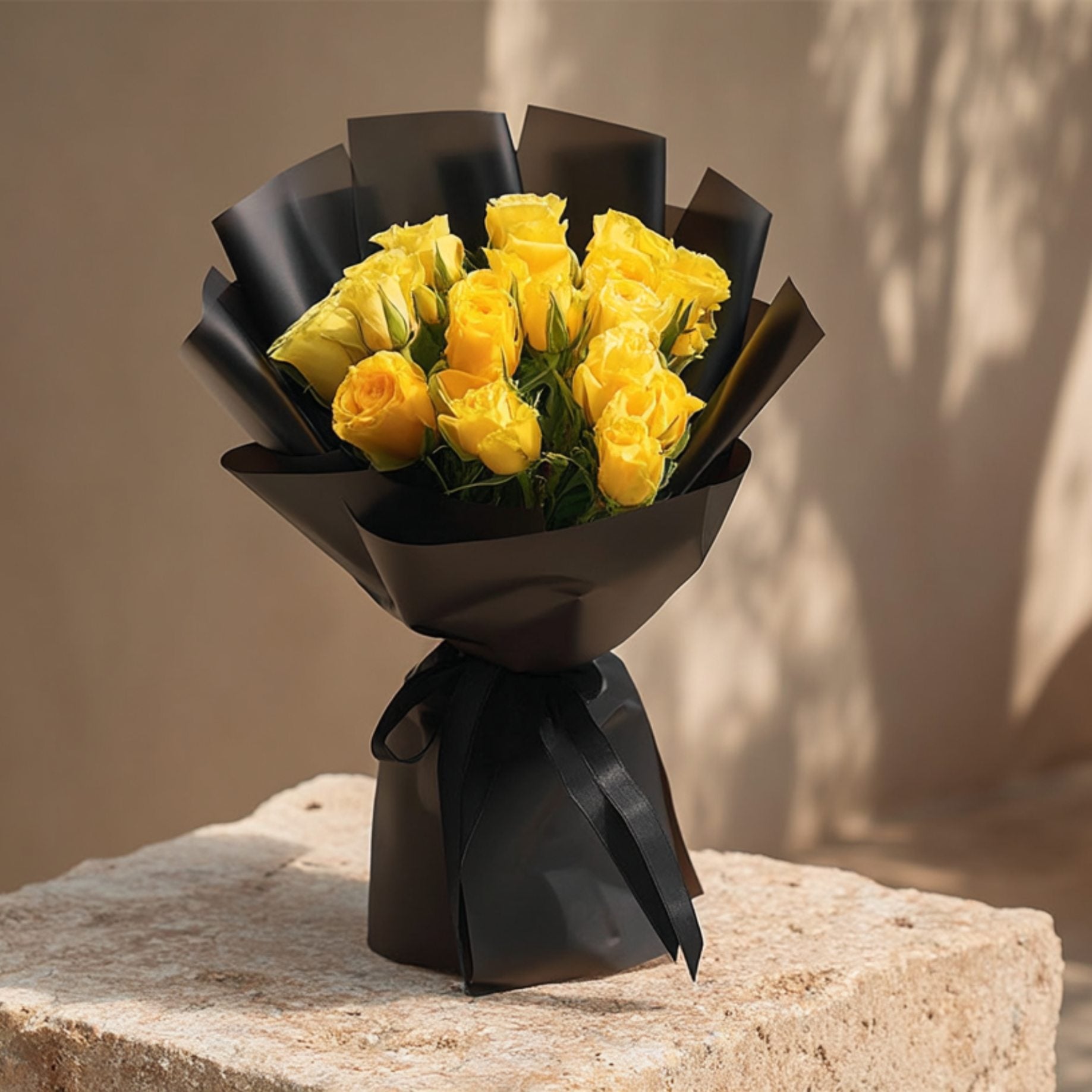 Hand-tied bouquet of 15 yellow roses in elegant black wrapping by Aiwa Flowers Dubai
