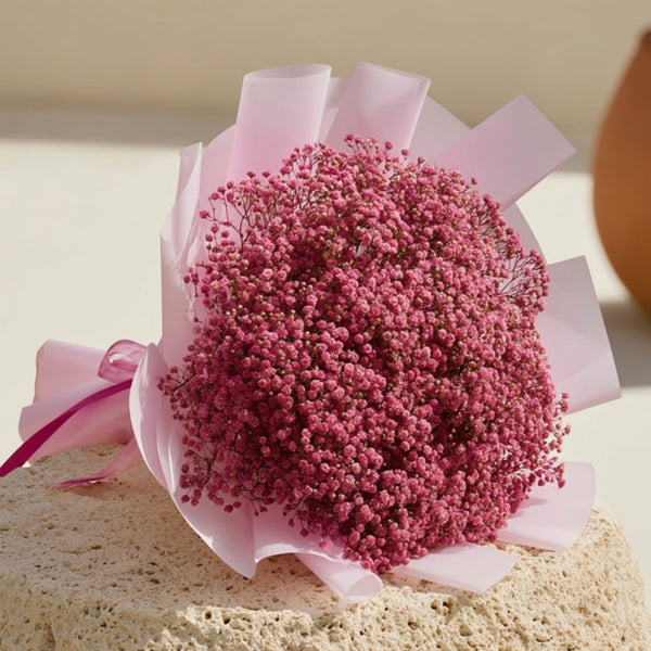 Hand-tied bouquet of delicate pink gypsophila wrapped in soft light pink paper, handcrafted by Aiwa Flowers in Dubai
