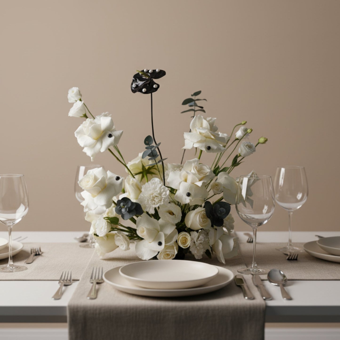 Domino centerpiece with ivory roses and modern black accents arranged on an elegant dining table.