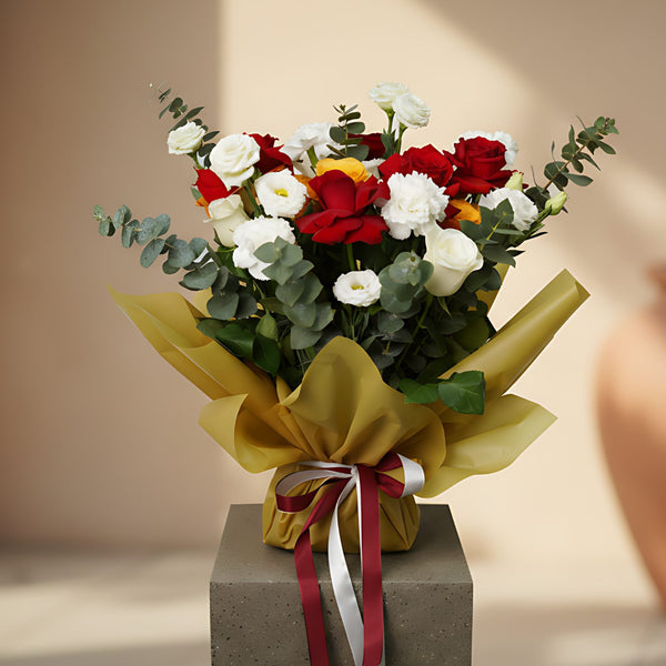 Eid Bliss hand-tied bouquet with mixed roses, white carnations, lisianthus, and eucalyptus in gold wrapping by Aiwa Flowers Dubai