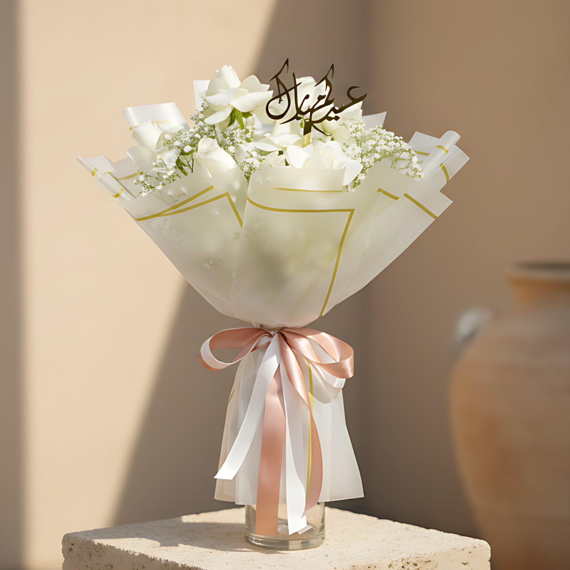 Eid Blooms hand-tied bouquet of white roses, white hydrangeas, gypsophila, and Arabic topper in trendy wrapping by Aiwa Flowers Dubai