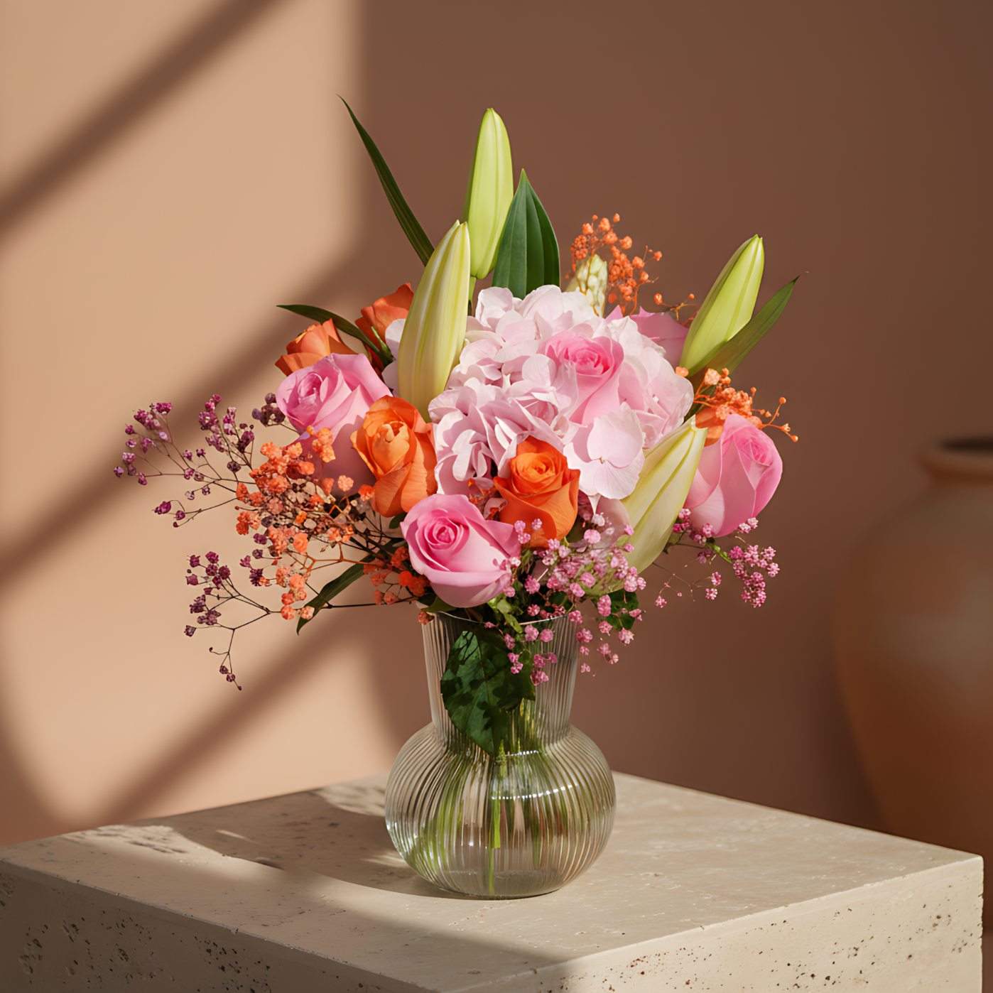 Elise floral arrangement with orange and pink roses, pink hydrangea, white lilies, and gypsophila in a clear glass vase by Aiwa Flowers Dubai
