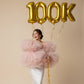 oversized gold foil balloons forming 100K with ribbons