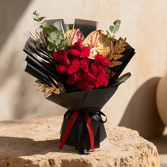 Hand-tied bouquet with roses, carnations, and anthurium in elegant black wrapping, handcrafted by Aiwa Flowers in Dubai