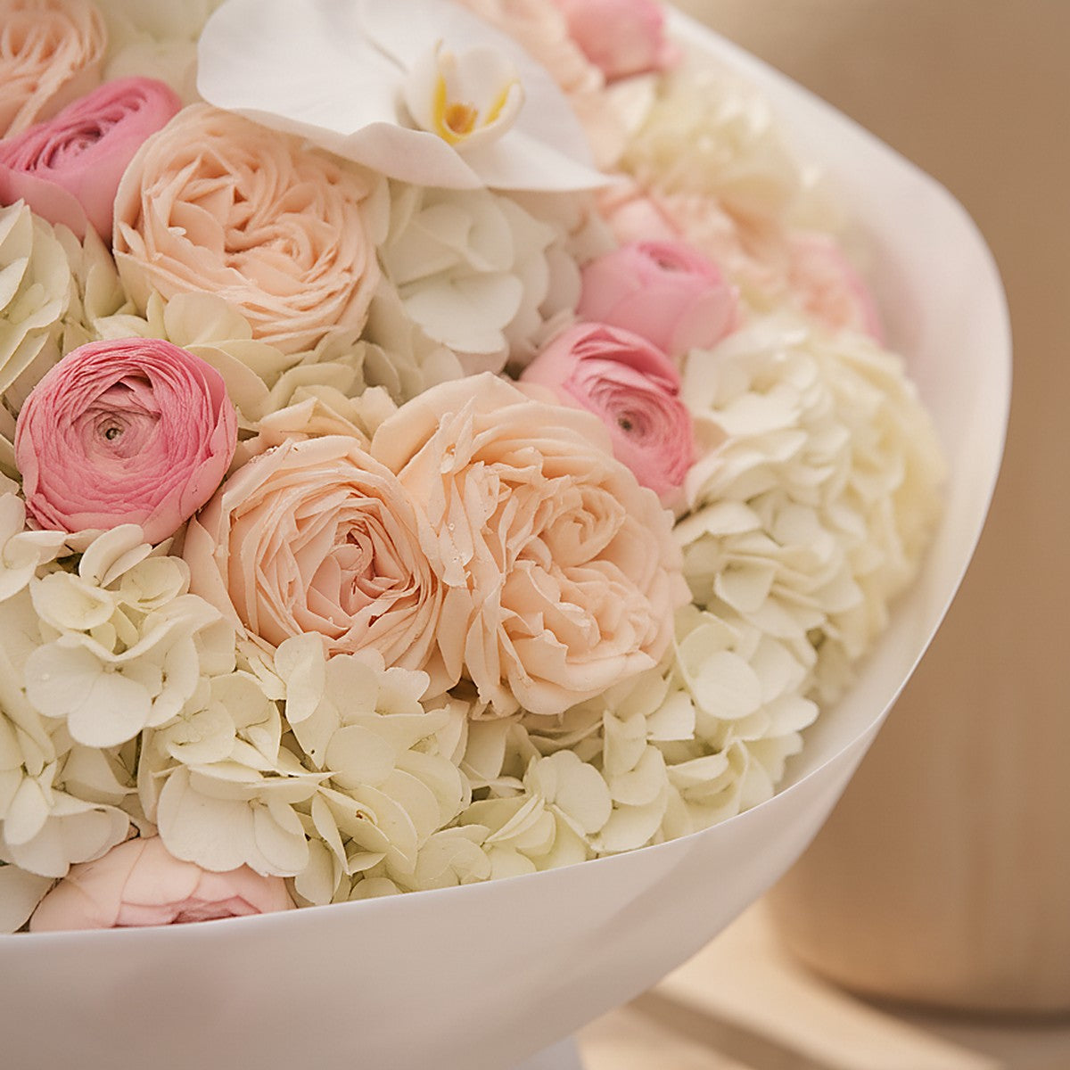 Ivory Orchid white hydrangea orchid and garden rose bouquet wrapped in white by Aiwa Flowers Dubai