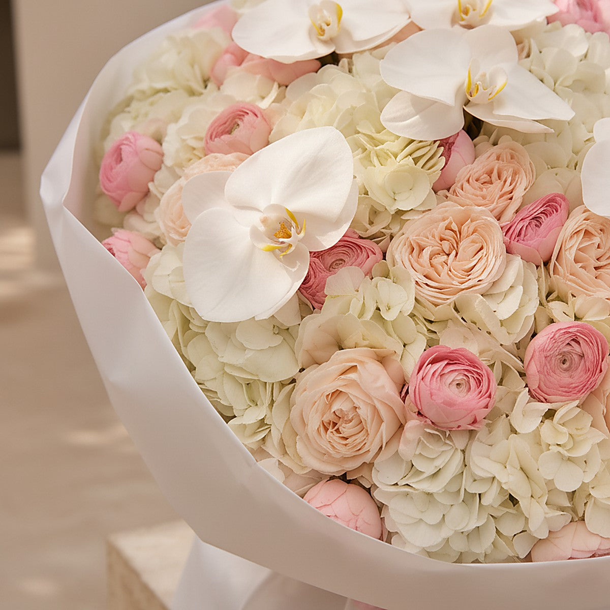Top-down view of Ivory Orchid hand-tied bouquet by Aiwa Flowers Dubai