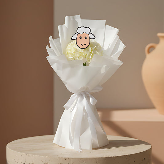 Kayouty hand-tied bouquet with white hydrangea and sheep picture design wrapped in white paper by Aiwa Flowers Dubai