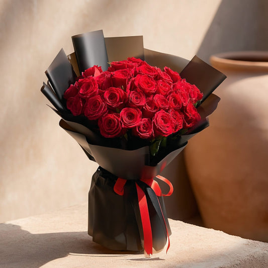 Hand-tied bouquet of 25 red roses in elegant black wrapping by Aiwa Flowers Dubai