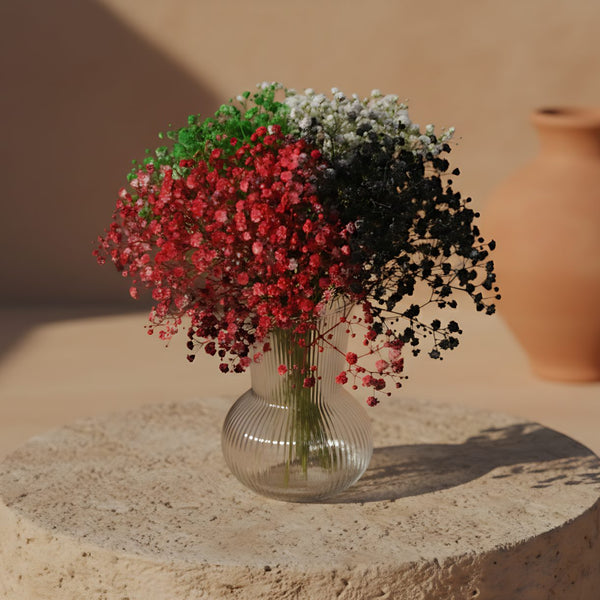 Prosperity floral arrangement with flag-colored gypsophila in a clear glass vase by Aiwa Flowers Dubai