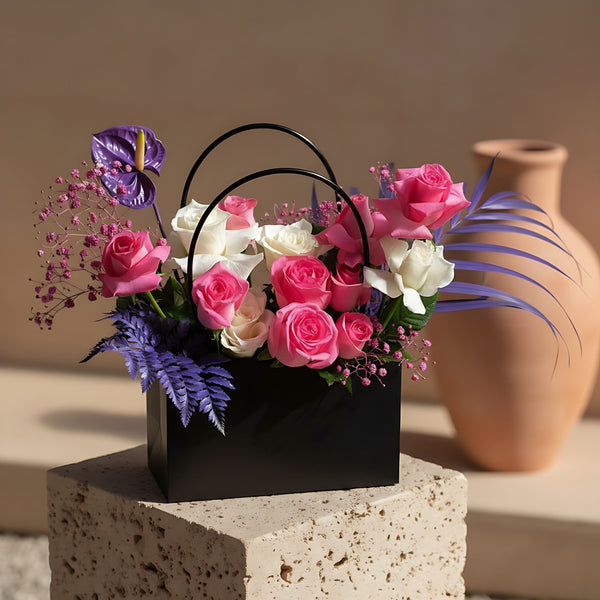 Purple Blush bag-box arrangement with pink and white roses, anthurium, gypsophila, and foliage by Aiwa Flowers Dubai