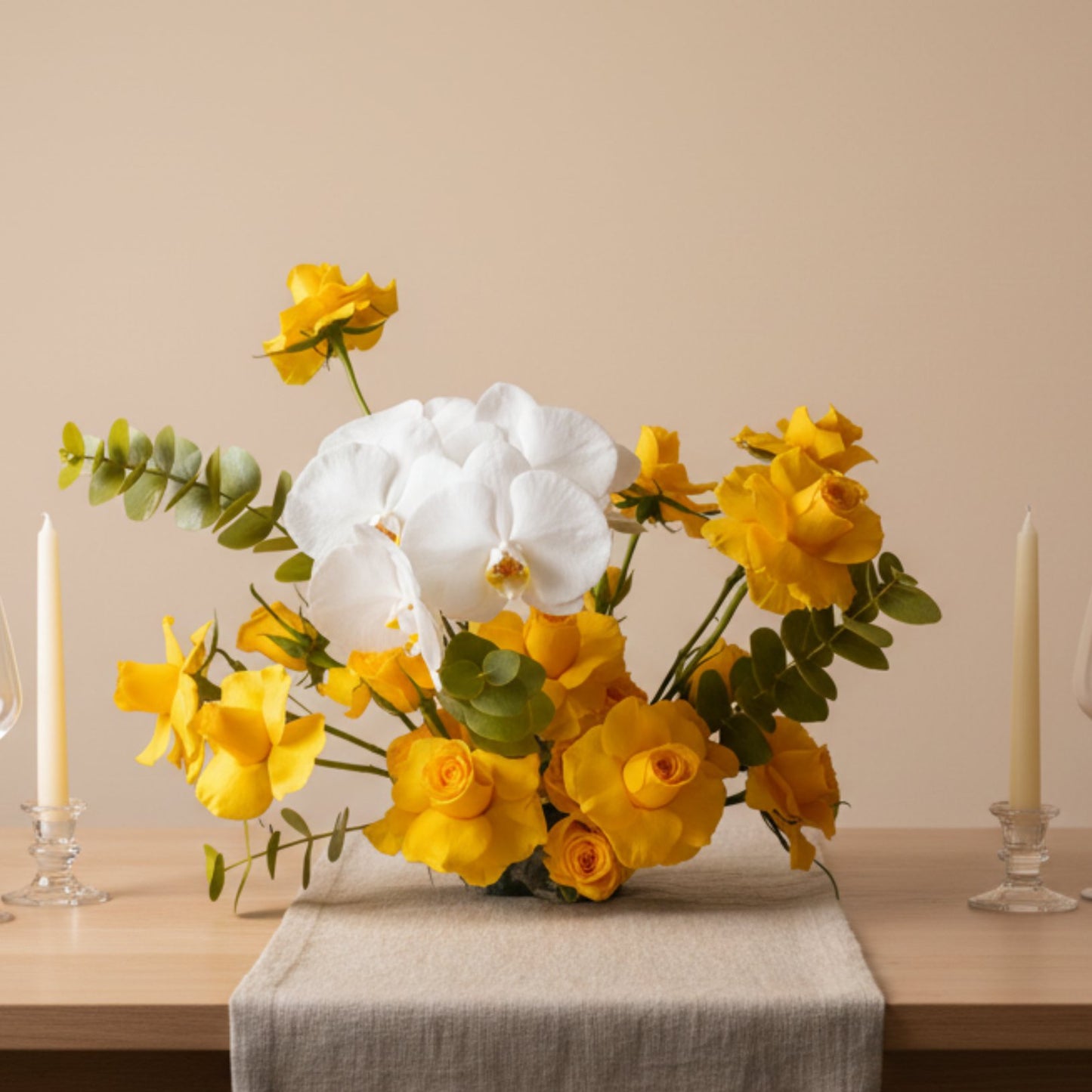 Sunshine Orchid Garden centerpiece with yellow roses, white orchid, and eucalyptus arranged on an elegant dining table.