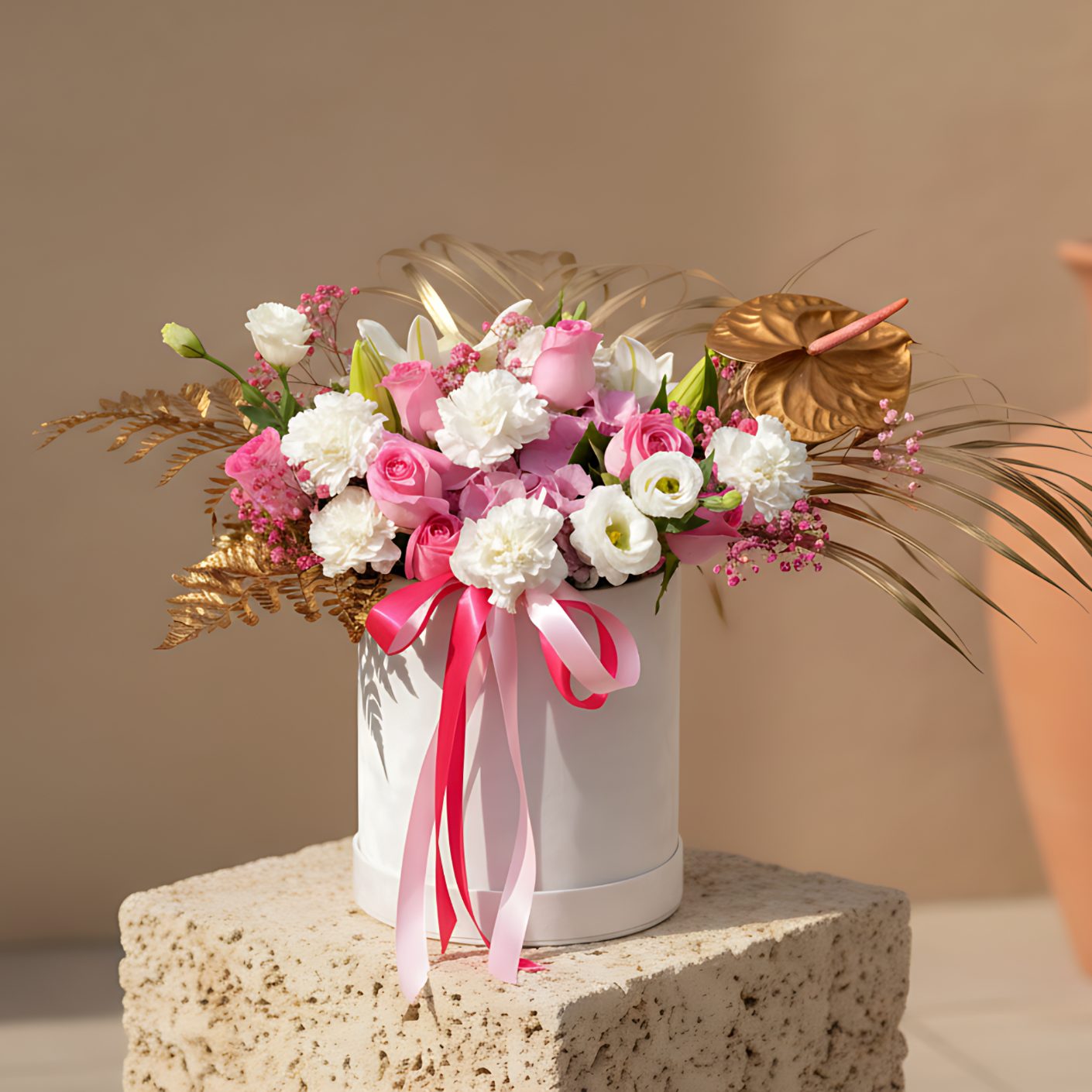 White velvet box arrangement with pink roses, hydrangea, lilies, carnations, and gold accents