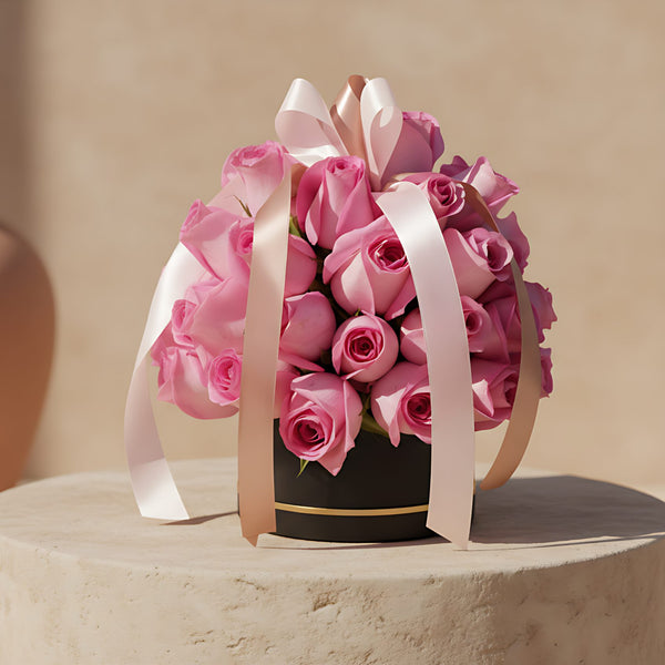 Elegant black box arrangement of 35–40 fresh pink roses symbolizing love and connection