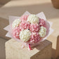 Top view of hydrangea bouquet with pink and white hydrangea blooms arranged in soft pink wrapping.