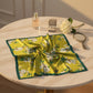 Floral printed silk scarf displayed on table with perfume and jewelry.