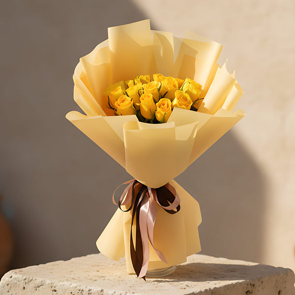 Hand-tied bouquet of 15 fresh yellow roses wrapped in elegant gold paper