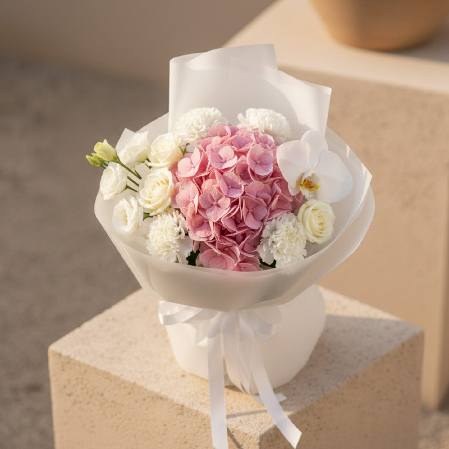 Top view of Muse bouquet with pink hydrangea centerpiece, white roses, orchid, and delicate white flowers.