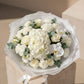 Top view of Pure Intention bouquet with white hydrangea, roses, orchid, and delicate white flowers.