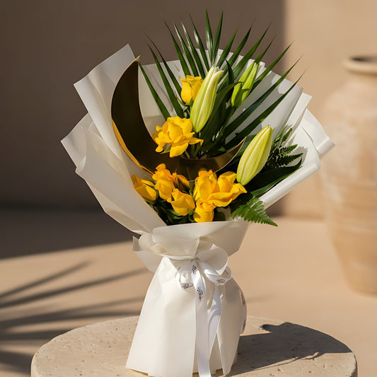 Luxury Ramadan hand-tied bouquet with yellow roses, a lily stem, greenery, and a moon-shaped topper in elegant white wrapping, available for delivery in Dubai.