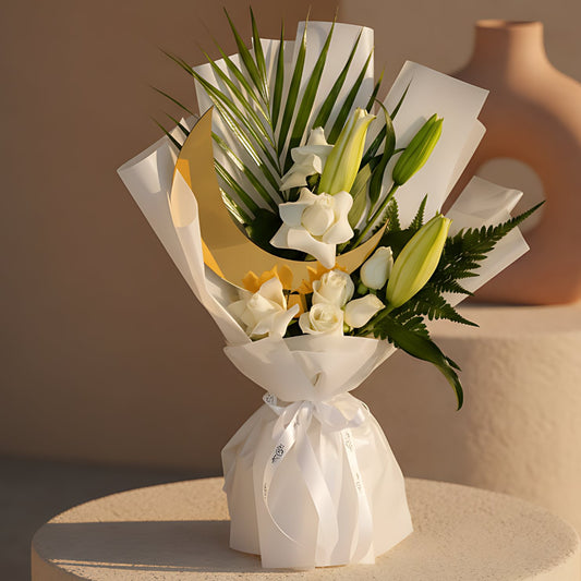 Luxury Ramadan hand-tied bouquet with white roses, a lily stem, fresh greenery, and a moon-shaped topper in elegant white wrapping, available for delivery in Dubai.