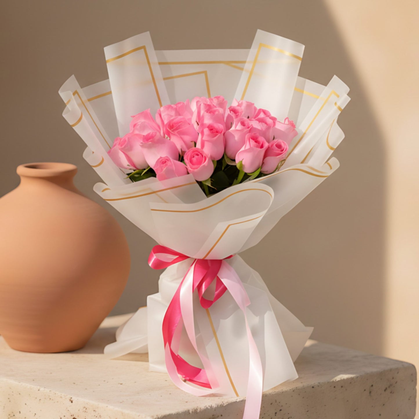Hand-tied bouquet of 25 fresh pink roses wrapped in a modern trendy paper