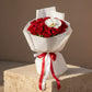 Royal Devotion bouquet with red roses and white orchid wrapped in elegant white paper.