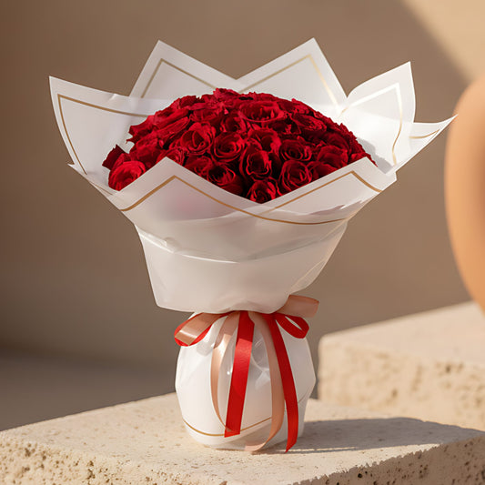 Hand-tied bouquet of 55 fresh red roses wrapped in modern trendy paper