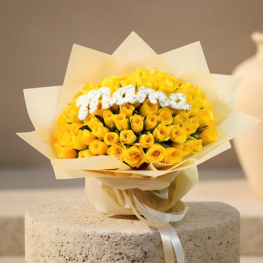 Hand-tied bouquet of 101 yellow roses with a Mama accent wrapped in luxurious gold paper