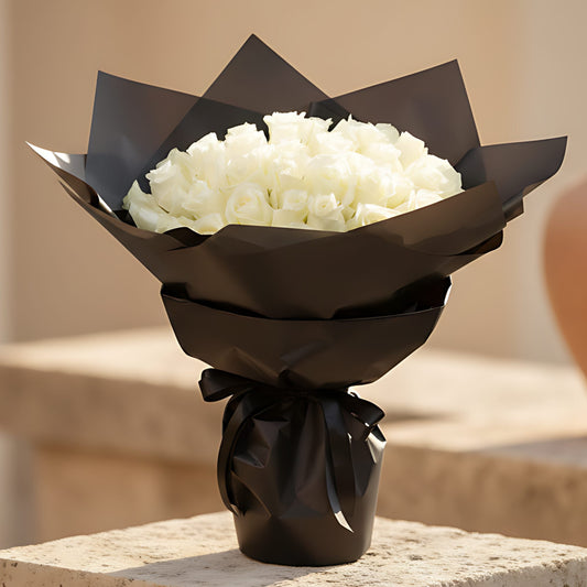 Hand-tied bouquet of 55 fresh white roses wrapped in elegant black paper